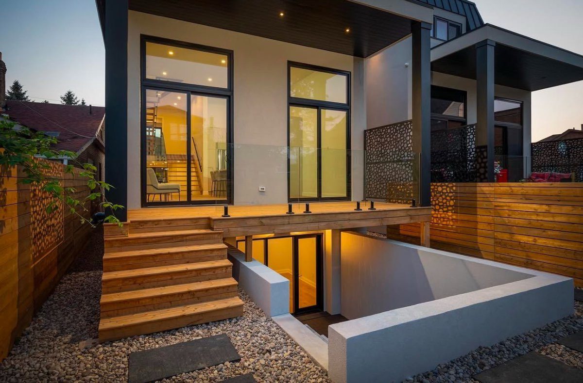 Modern cedar deck with a glass railing and walkout behind a contemporary Ottawa home