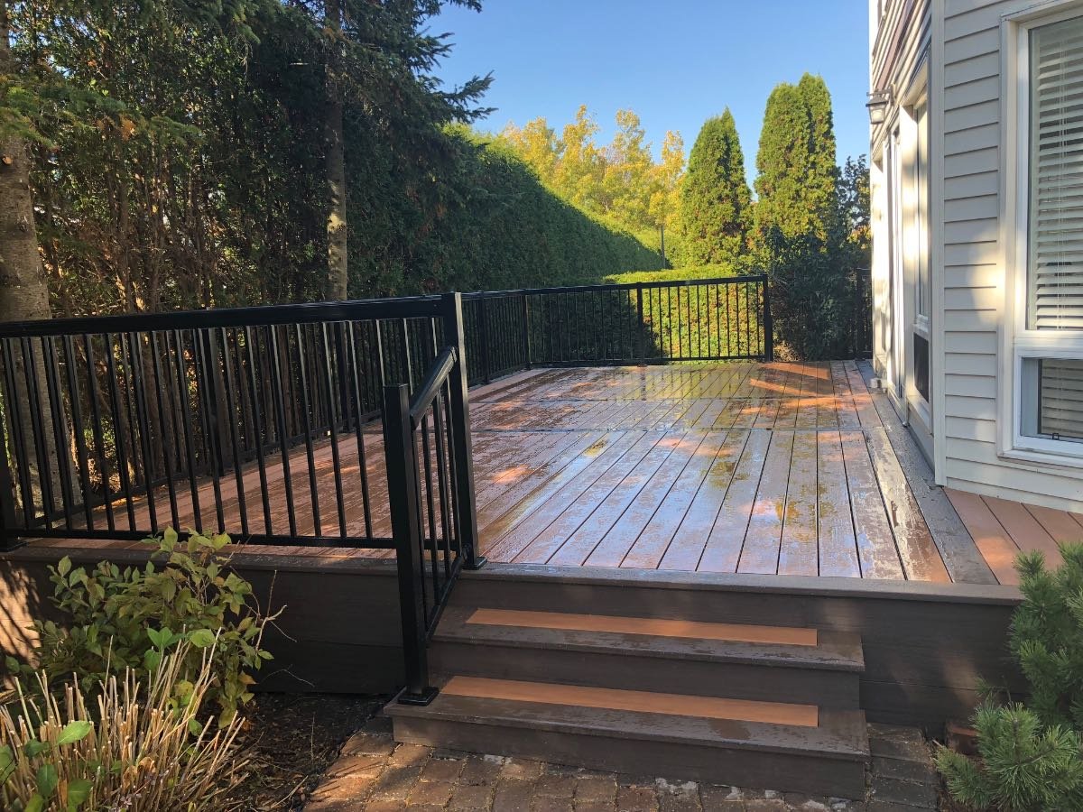 Warm-toned deck with black aluminium railing in low evening sun