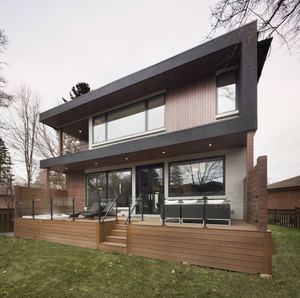 Modern home rear composite deck lit at dusk