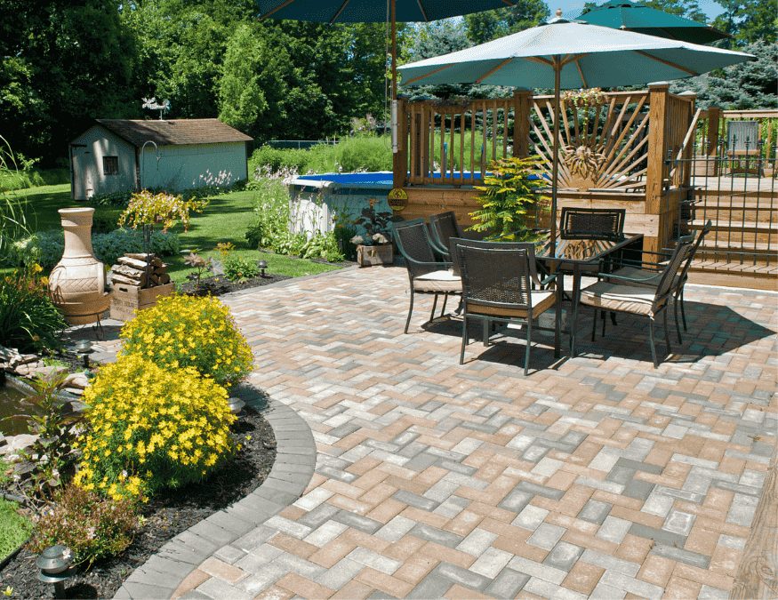 Multicolour interlock paver patio with a dining set and landscaping