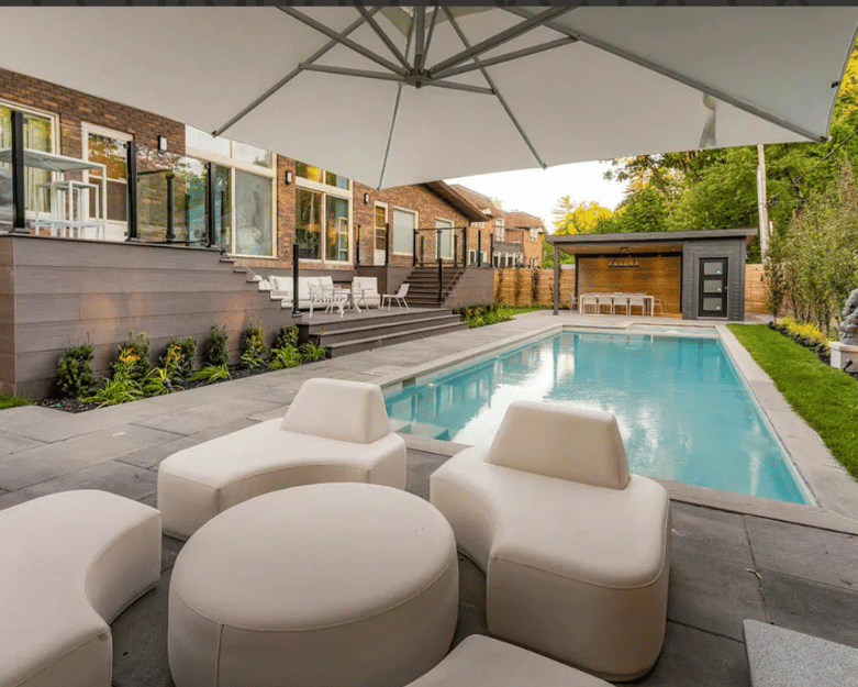 Luxury pool cabana with lounge seating and changing area beside backyard pool in Ottawa
